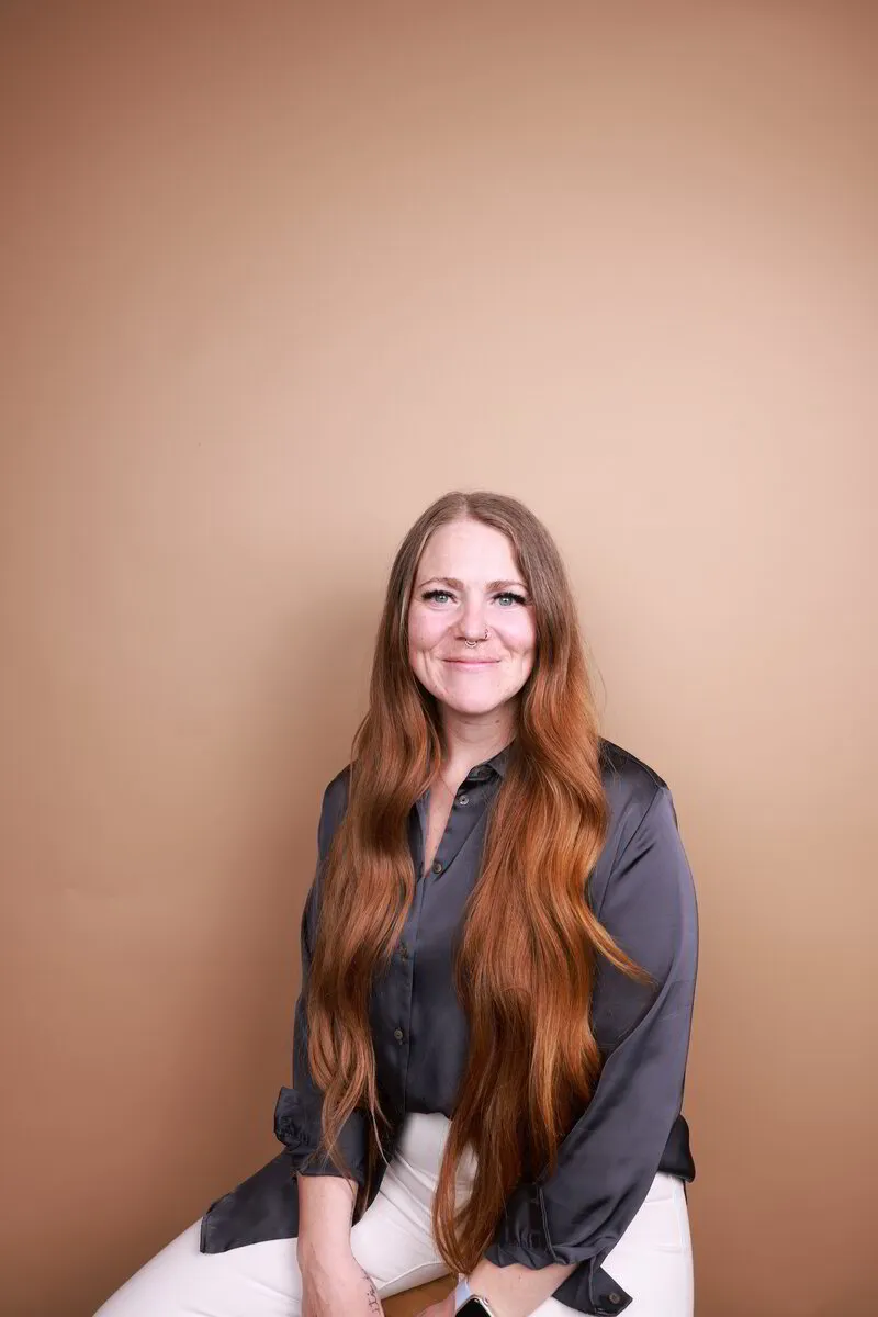 Mary J smiling, seated against a warm tan backdrop